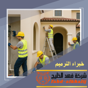 عمال شركة ترميم منازل السودة أثناء ترميم واجهة منزل قديم